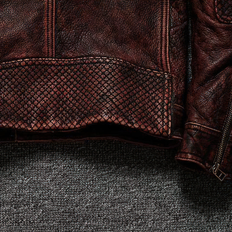 Close-up of a durable brown biker jacket showcasing textured leather and unique detailing on the hem.