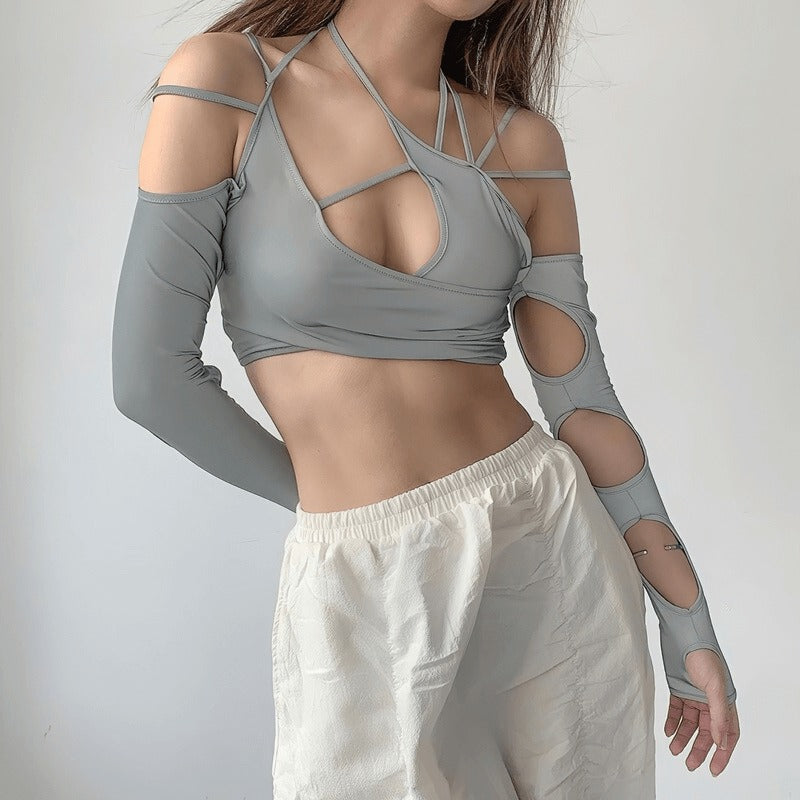 Model wearing a sexy cut out long sleeve crop top in gray, featuring stylish asymmetrical design and cutouts.