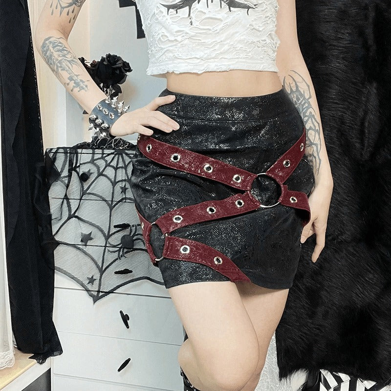 Stylish women's high-waisted mini skirt with rivet straps and rings in a punk gothic outfit.