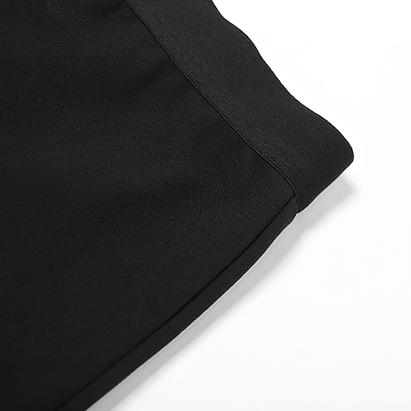 Close-up of the fabric detailing on an elegant black halter dress with a sleek waistline.