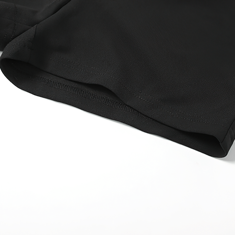 Close-up of the hem of a stylish black halter dress, showcasing its smooth fabric and elegant design.