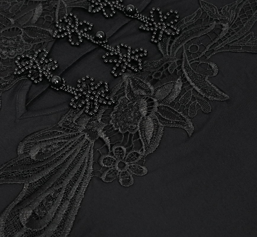 Close-up of intricate black lace detailing with floral designs and embellishments on a gothic-style dress.