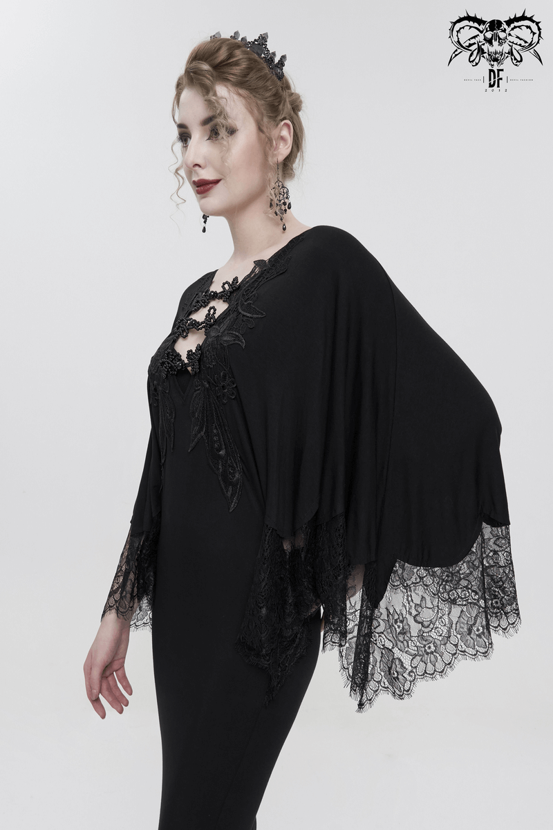 Elegant woman in a black lace mermaid dress with cape sleeves, showcasing gothic style and luxurious details.