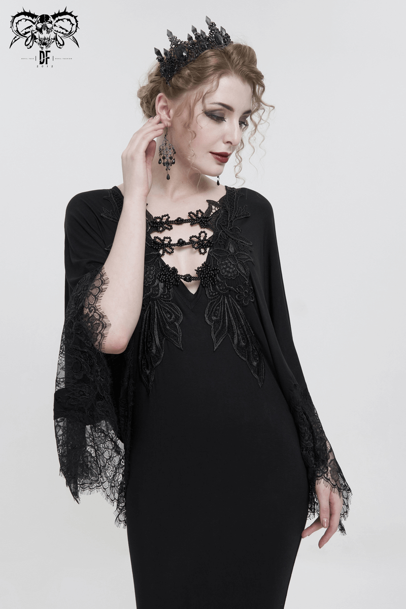 Elegant woman in black lace mermaid dress with cape sleeves, highlighting gothic fashion and intricate lace details.