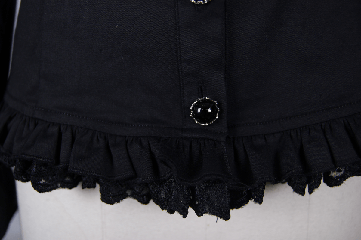Close-up of the elegant black gothic shirt's frilled hem and decorative button with lace detail.