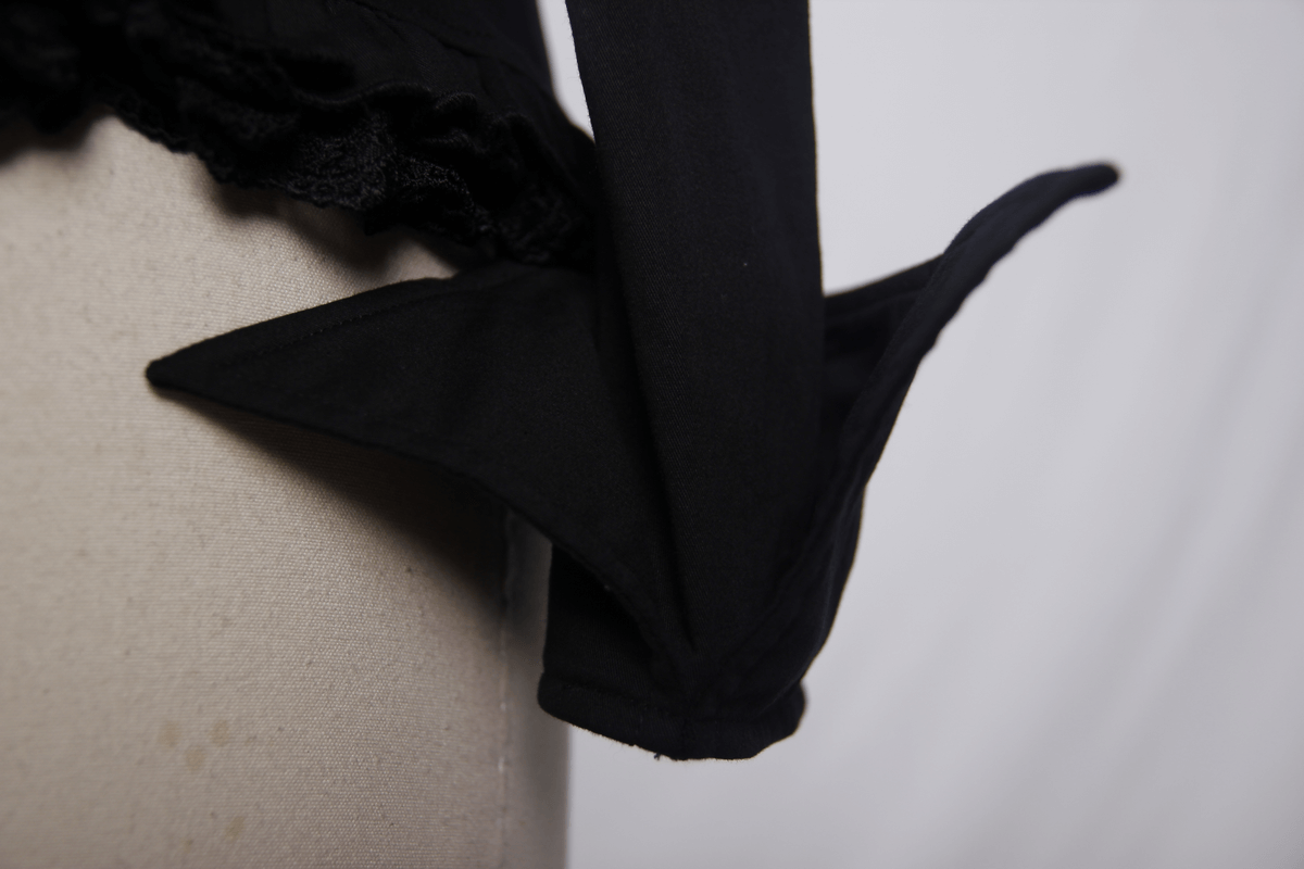 Close-up of an elegant black Gothic shirt detail with unique collar design and lace trim.