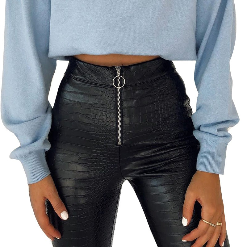 Elegant high-waisted faux leather skinny pants with snake print and zip detail, styled with a cozy blue top.