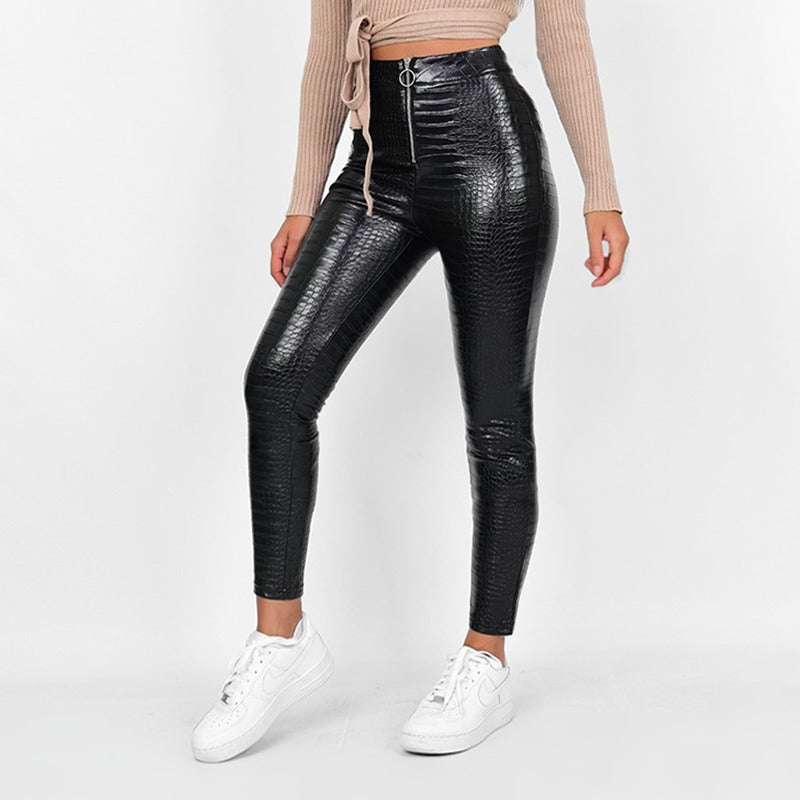 Elegant high waist faux leather skinny pants with snake print, perfect for rock and goth styles, paired with casual sneakers.