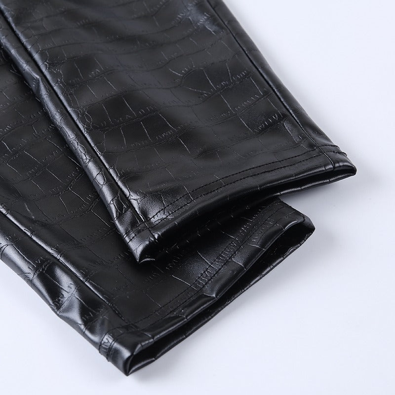 Close-up of elegant high waist faux leather pants with snake print texture, perfect for rock and goth styles.