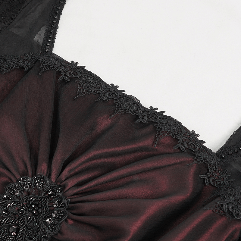 Close-up of the elegant appliquéd design on a wine red dress with black lace details.