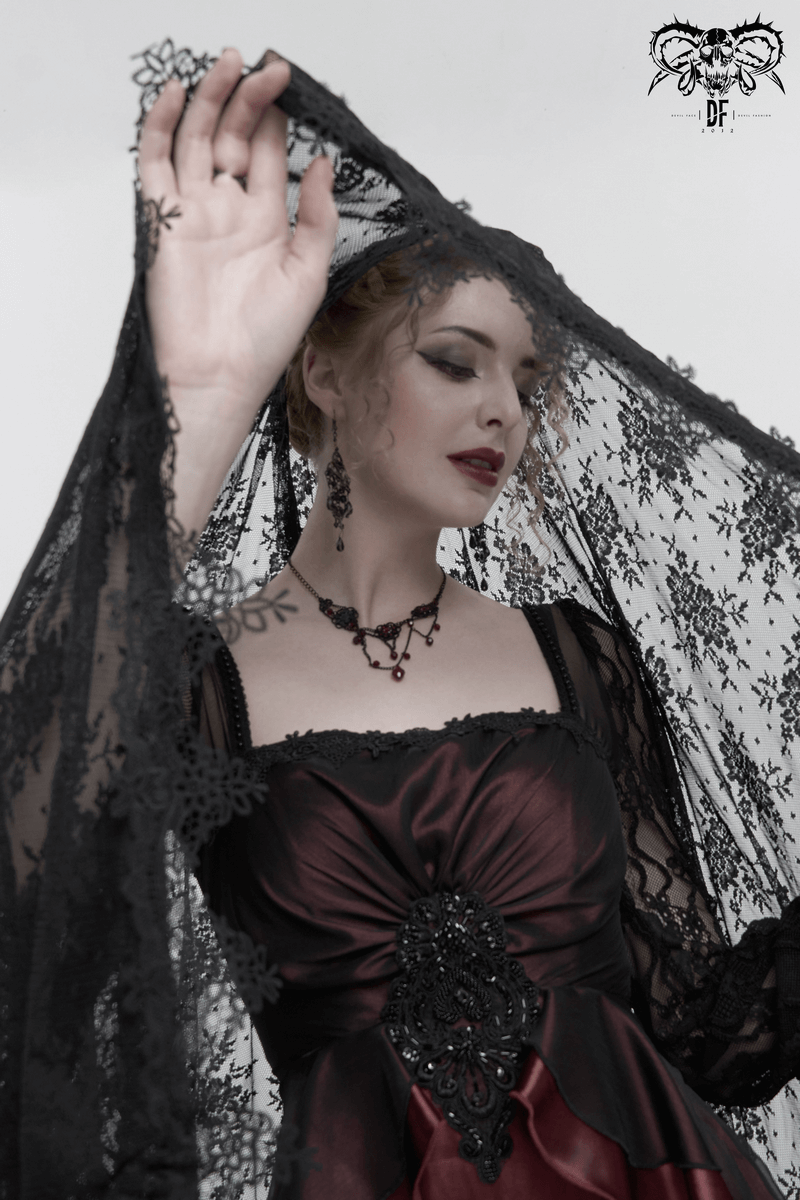 Elegant woman in a wine red dress with black lace, showcasing gothic style and intricate appliqué details.