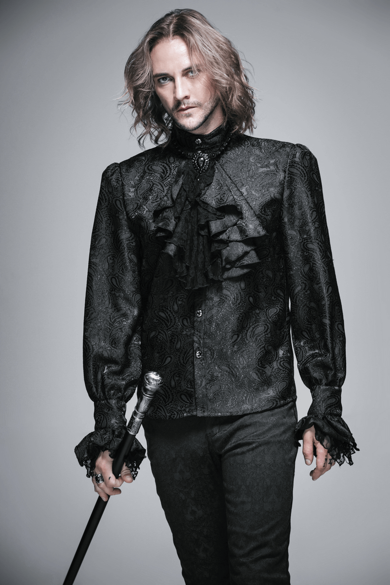 Model wearing a black patterned Victorian shirt with ruffles, showcasing a gothic style and holding a sword.