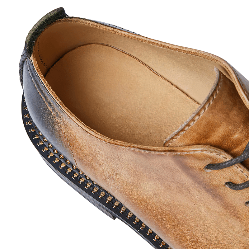Close-up of elegant men's leather shoes featuring breathable design and stylish lace-up details.