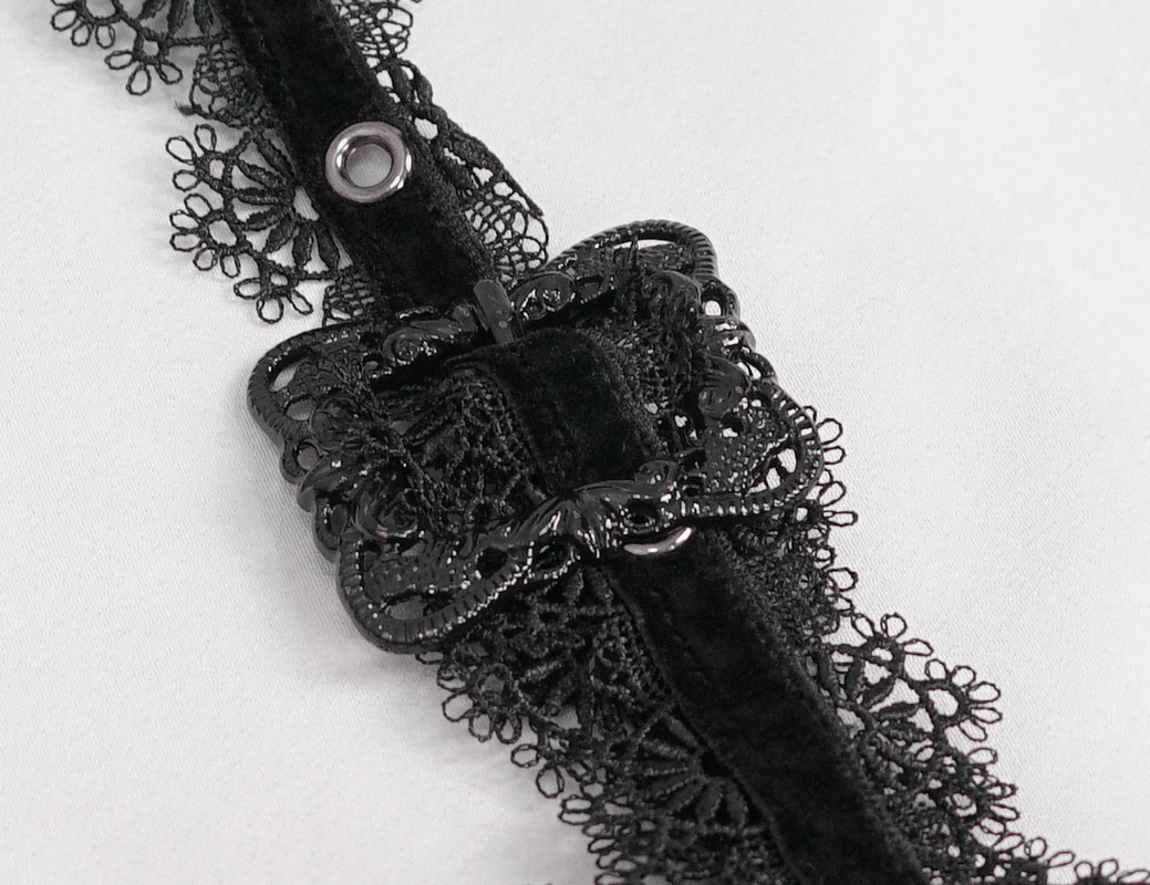 Close-up of black lace detail and buttons on elegant off-shoulder shirt, showcasing gothic style craftsmanship.