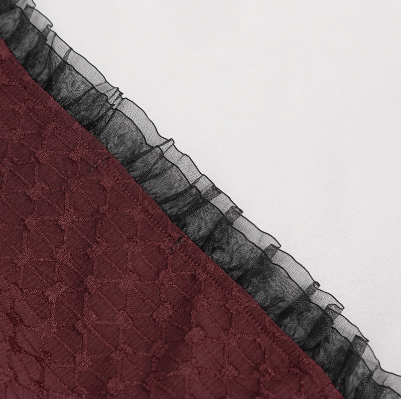 Close-up of burgundy lace fabric with a black ruffled trim for elegant gothic clothing.