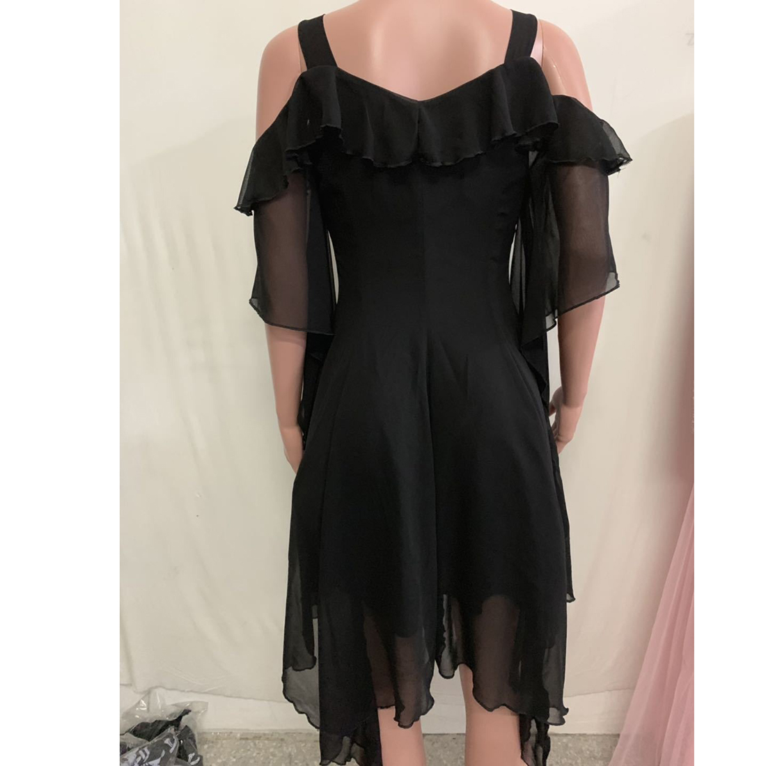 Back view of an elegant off-shoulder black dress with ruffled sleeves, showcasing a stylish gothic fashion flair.