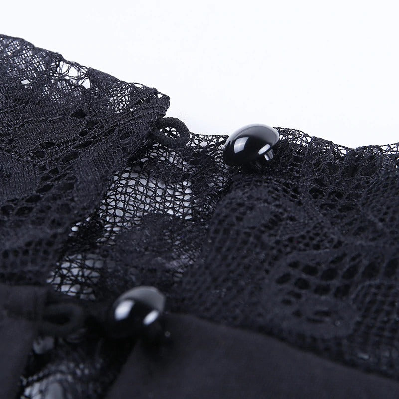 Close-up of elegant black lace detailing on dress with glossy buttons, showcasing charm and style.