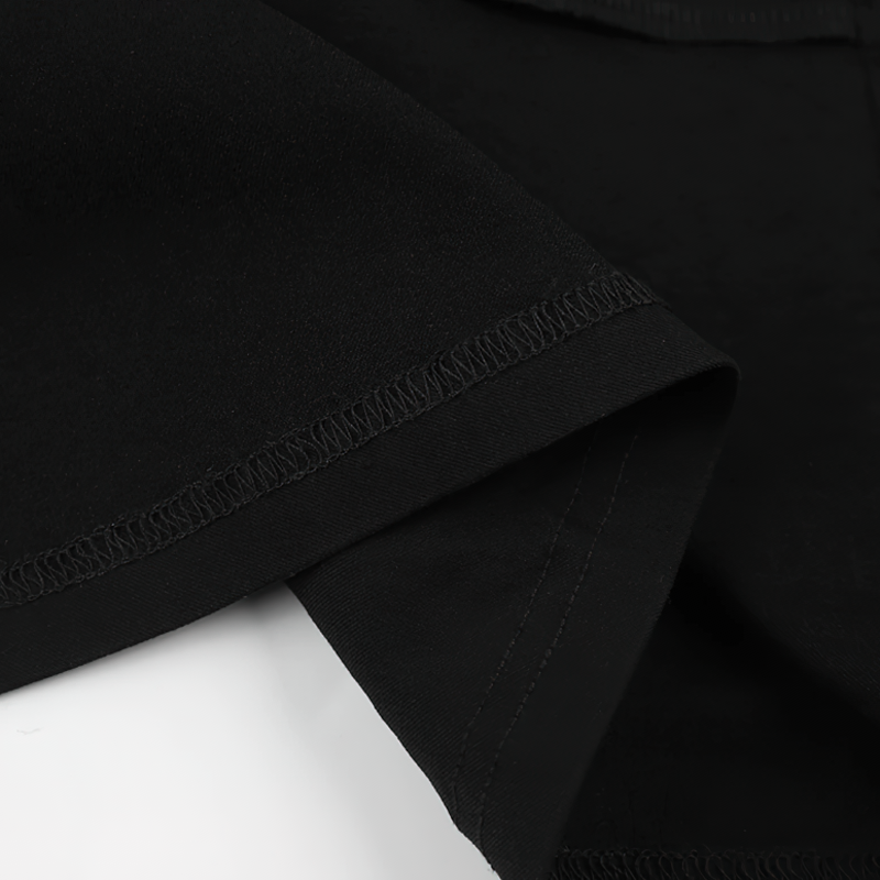 Close-up of the elegant black fabric and stitching of a women's long dress with deep neck and sleeves.