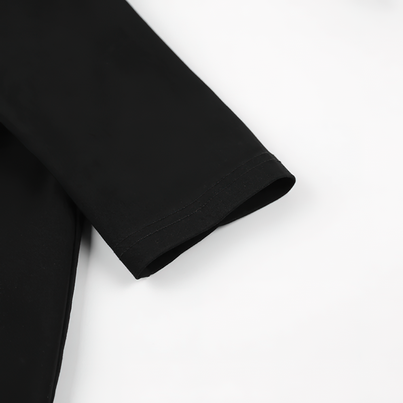 Close-up of elegant long sleeve detail from a women's black dress with deep neck design.