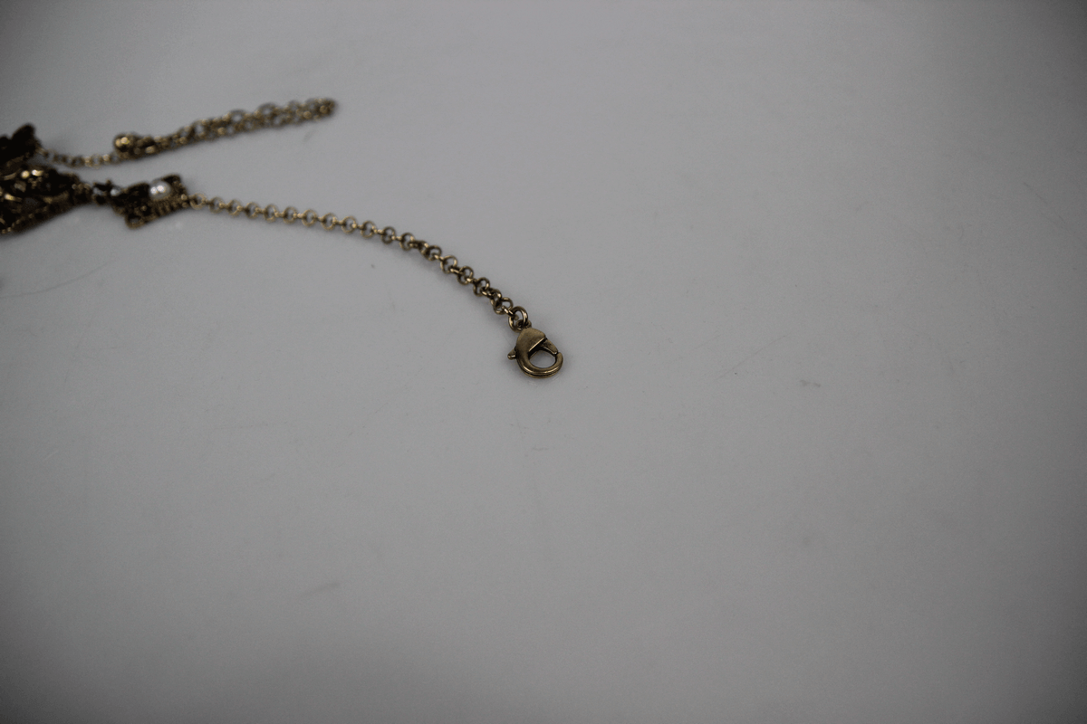 Close-up of a gold necklace clasp showcasing the intricate design and chain details, ideal for a retro pearl pendant necklace.