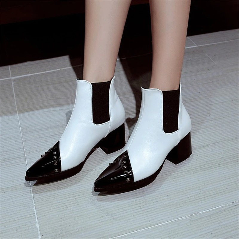 Elegant white and black pointed ankle boots with spikes, perfect for casual style and elegance.