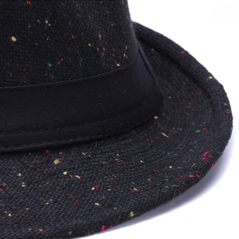 Close-up of an elegant woolen hat with a black ribbon and a wide brim, featuring colorful speckles.