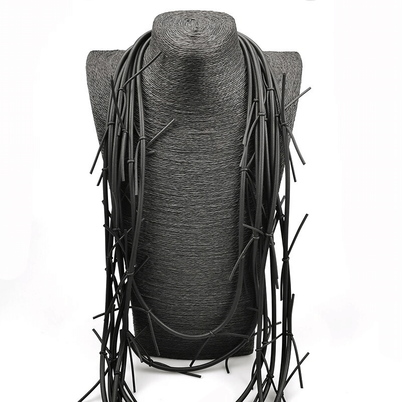 Stylish long black necklace displayed on a mannequin, perfect gothic accessory for women's outfits.