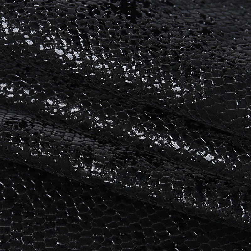 Black textured fabric with shiny finish, perfect for punk-style outfits and high-waisted mini skirts.