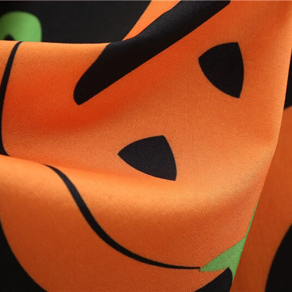 close-up of pumpkin print fabric on a Halloween dress, showcasing vibrant orange and black colors