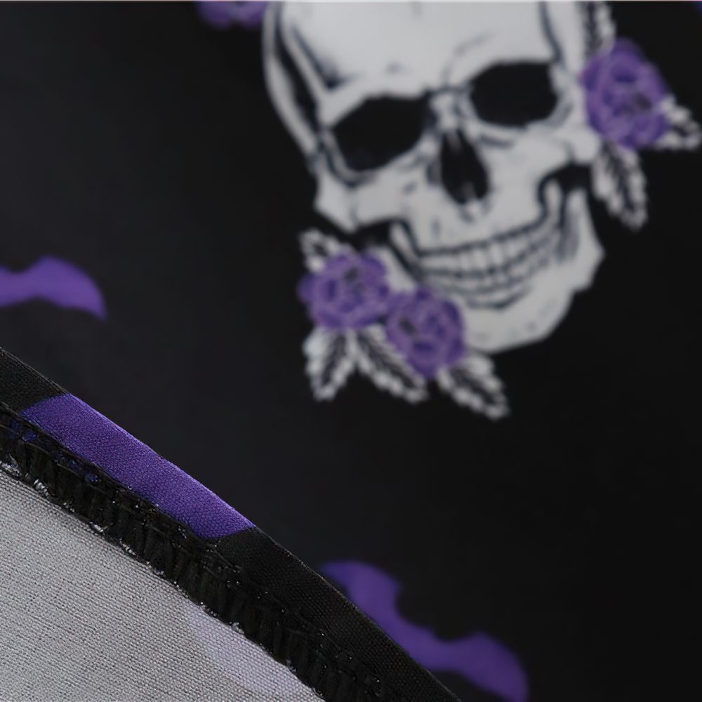 Close-up of a black fabric showing a skull and purple floral print, perfect for a Halloween outfit.