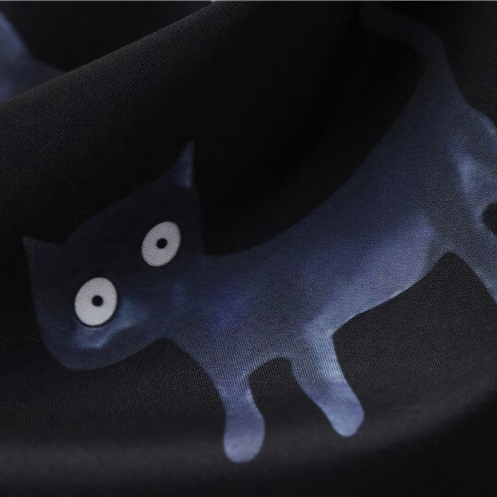 Close-up of a playful black cat print on fabric, perfect for Halloween-themed clothing.
