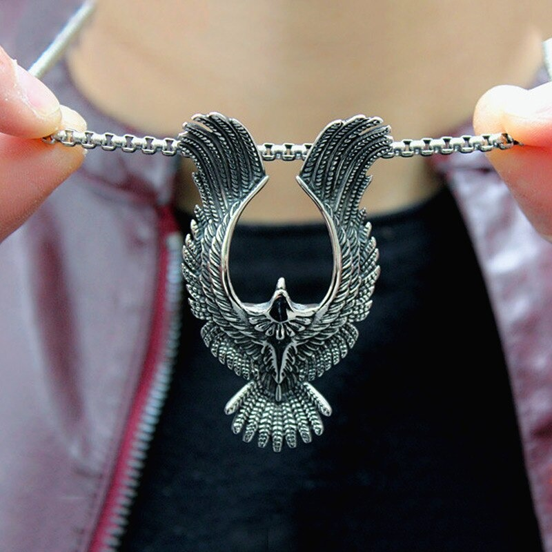 Stainless steel phoenix pendant held by hands, showcasing retro unisex jewelry with intricate details.