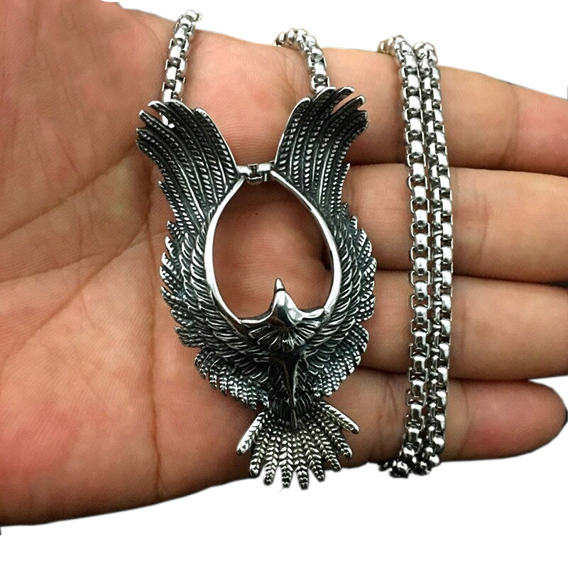 Retro stainless steel phoenix pendant held in hand, stylish unisex jewelry perfect for both men and women.