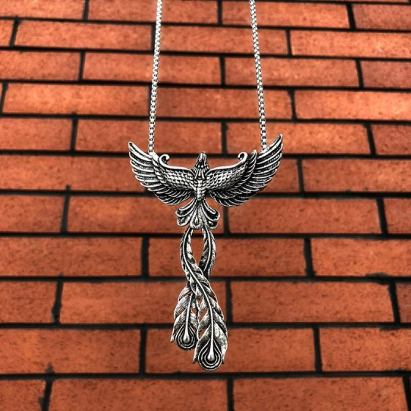 316L stainless steel phoenix pendant with open wings, retro style necklace against brick background.