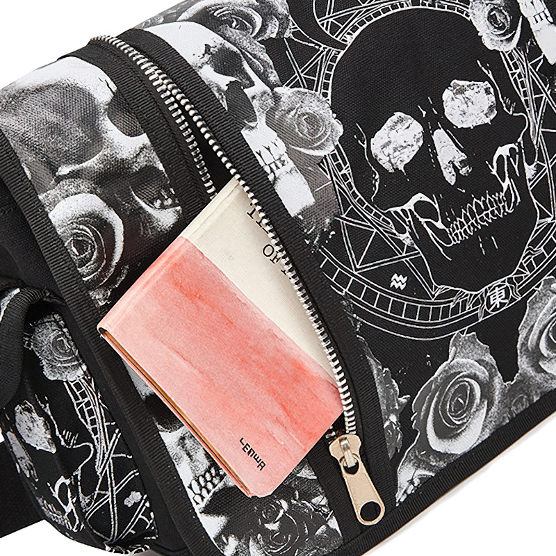 Close-up of a black gothic shoulder bag featuring a skull print and a zipped pocket with a pink item peeking out.