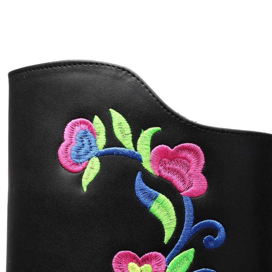 Close-up of flower embroidery on black PU leather mid-calf boots, showcasing vibrant colors and elegant design.