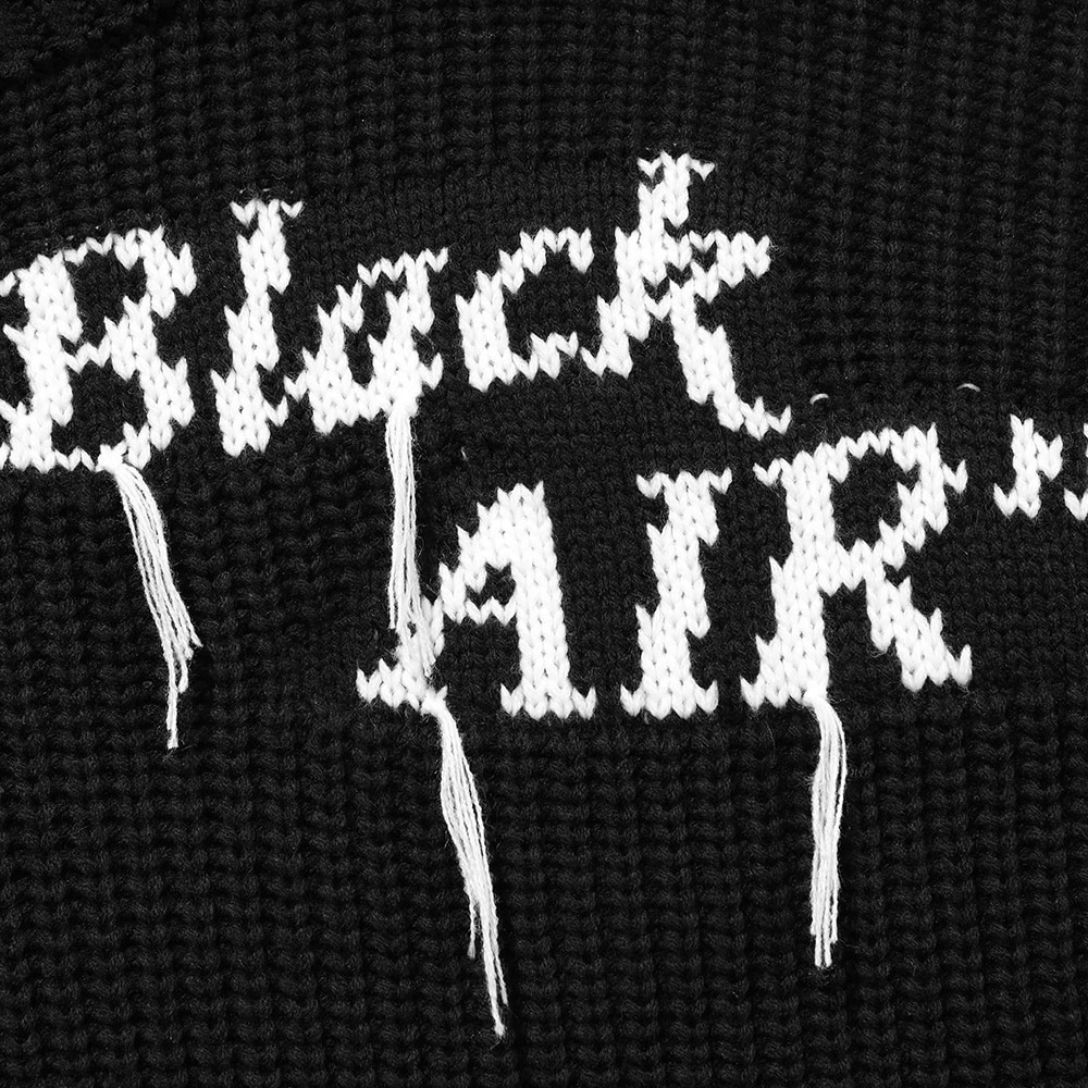 Close-up of a black sweater with white 'Black AIR' print, showcasing gothic streetwear style.