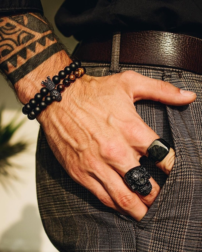 Gothic unisex bracelet set with skull and crown charms, styled with edgy finger rings.