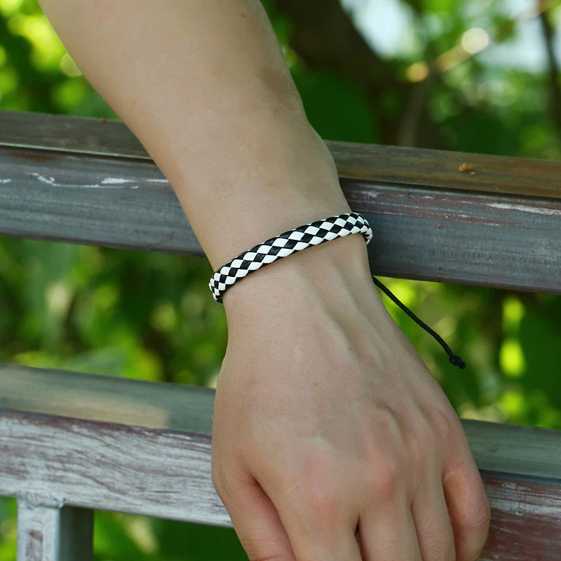 Handmade punk style braided leather bracelet in black and white worn on wrist, perfect for unisex punk fashion.