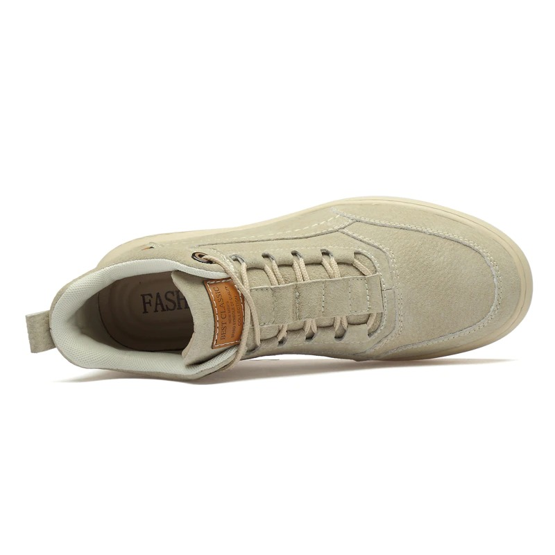 Top view of stylish men's classic suede boots in light color with rubber sole for casual wear.