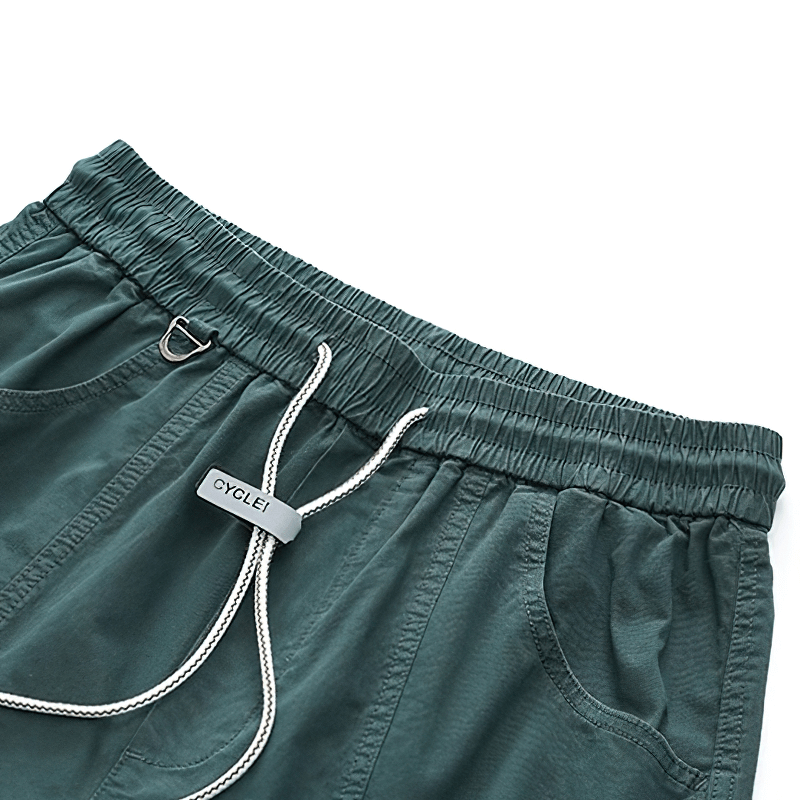 Close-up of casual elastic waist cargo pants with drawstring in teal color, showcasing modern design and pockets.