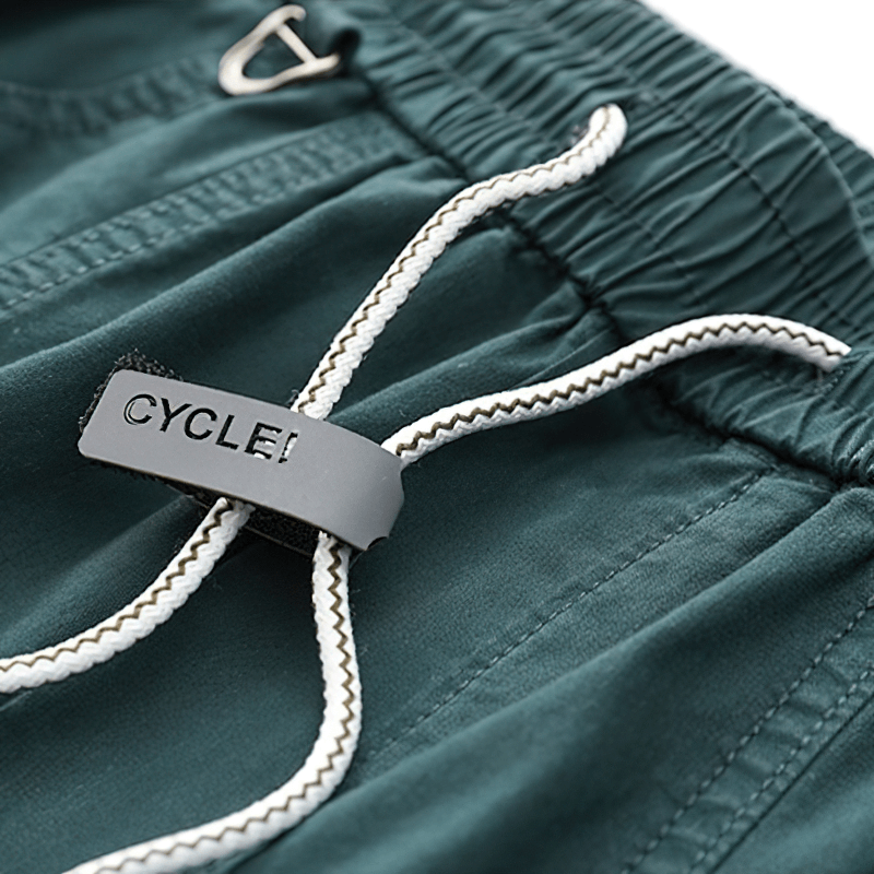 Close-up of drawstring detail on fashion harem pants featuring a logo tag, showcasing casual style and comfort.