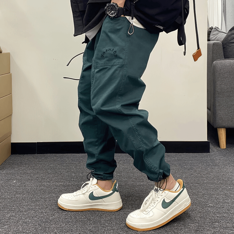 Casual harem pants with drawstring in dark green, paired with stylish sneakers for a trendy look.