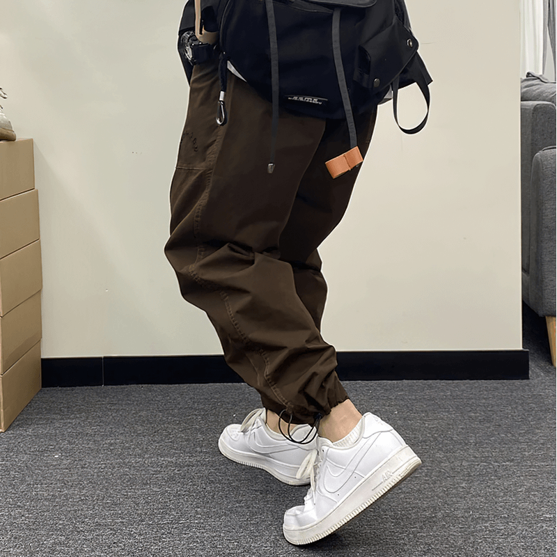 Fashion drawstring harem pants in brown paired with white sneakers, perfect for casual styling and comfort.