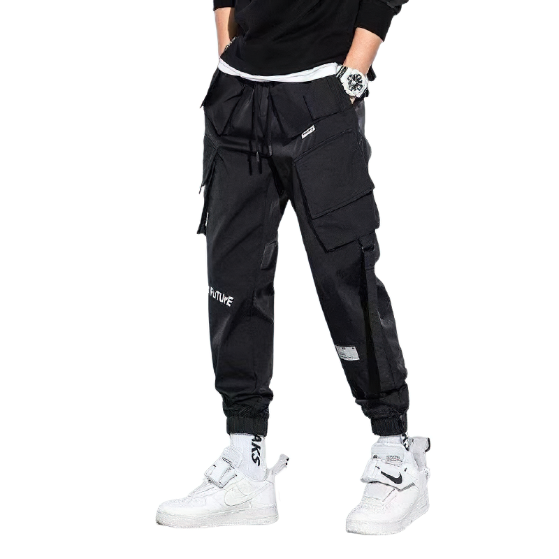 Stylish men's fashion cuffs pants in trendy black, featuring multiple pockets and paired with casual streetwear sneakers.