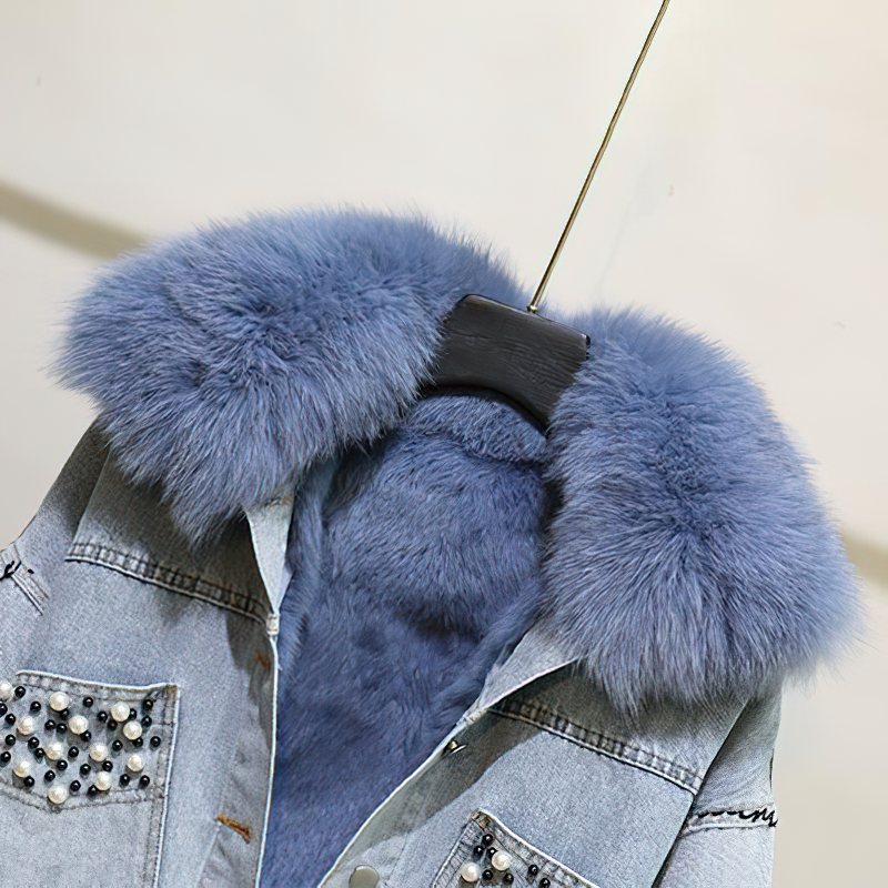 Close-up of the soft blue fur collar of a women's denim parka jacket with beaded embroidery.