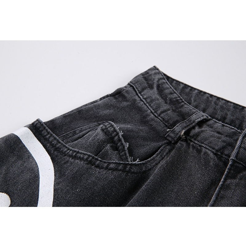 Close-up of comfy black jeans with a ghost print, showcasing the waistband and pocket detail.