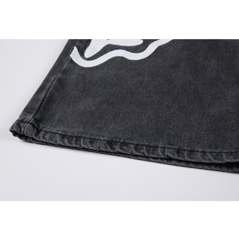 Close-up of black jeans hem featuring a playful ghost print design, showcasing casual style and denim texture.