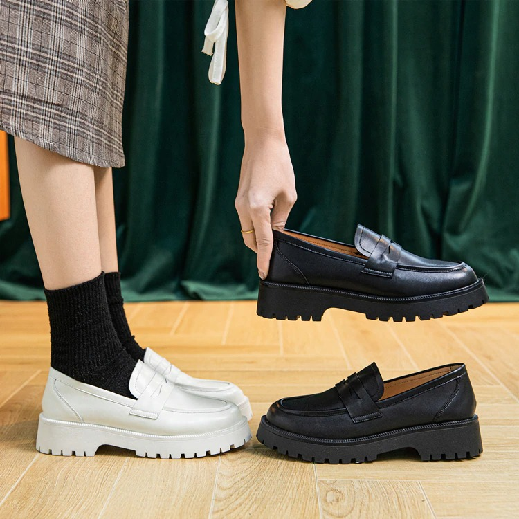 Stylish female leather loafers in black and white, showcasing thick soles perfect for casual spring outfits.