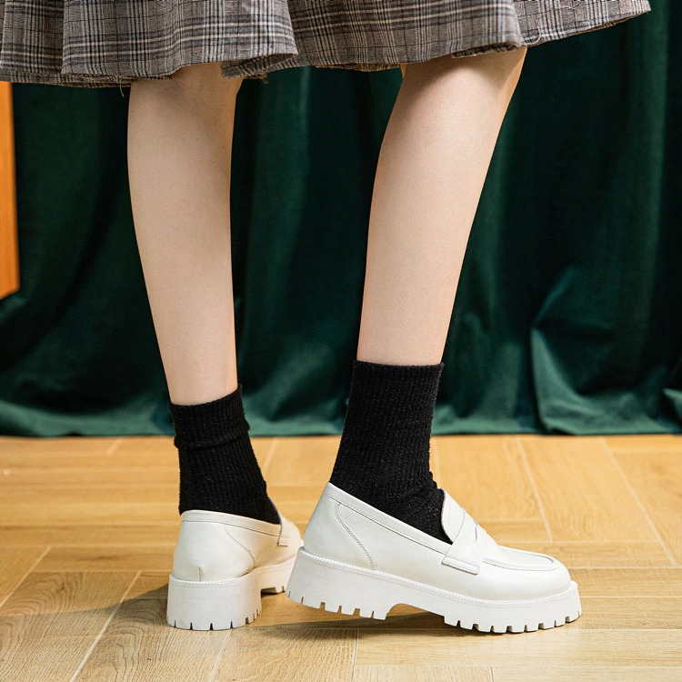 Fashion female genuine leather loafers with thick soles, paired with black socks, showcasing a casual spring style.